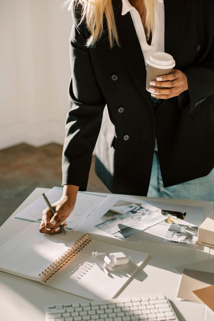 Interior designer reviewing plans and ideas at a desk with coffee in hand